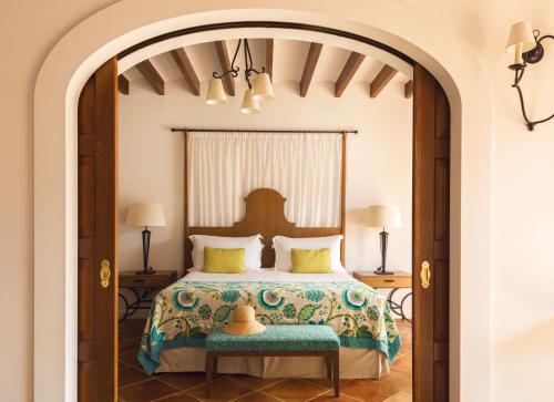 a bedroom with a bed and an arched doorway at La Residencia, A Belmond Hotel, Mallorca in Deia