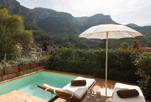 an umbrella and chairs next to a swimming pool at La Residencia, A Belmond Hotel, Mallorca in Deia