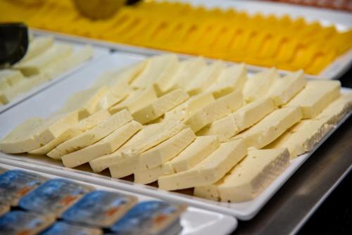 a tray of cheese on a table with other foods at Hotel Titanic Penedo in Penedo