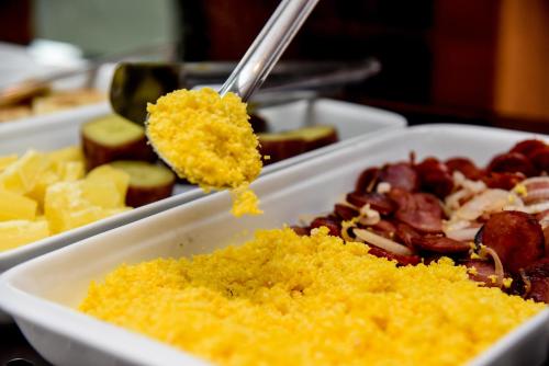 a bowl of food with a spoonful of mustard at Hotel Titanic Penedo in Penedo