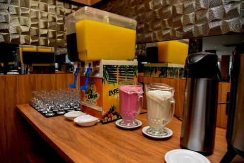 a counter with glasses and a coffee maker on it at Hotel Titanic Penedo in Penedo