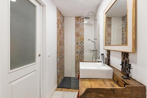 y baño con lavabo blanco y espejo. en Judería Suites, en Córdoba