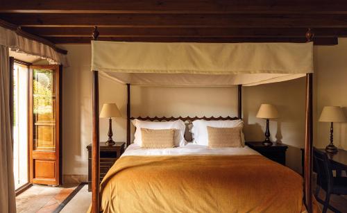 a bedroom with a large bed with a canopy at La Residencia, A Belmond Hotel, Mallorca in Deia