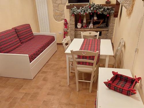 - un salon avec un canapé, une table et des chaises dans l'établissement Nel vicolo dei Baci - Casa vacanze al Bacio, à Spello