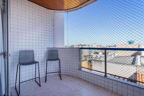 a room with two chairs and a large window at Cobertura de alto padrão com vista para a Praia do Forte in Cabo Frio