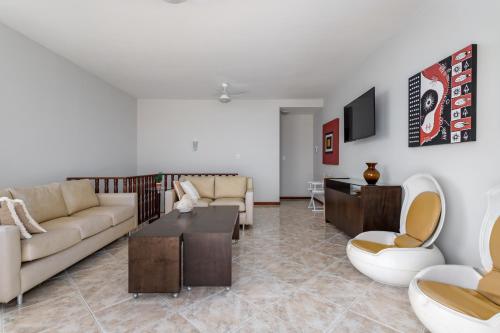 a living room with a couch and a table at Cobertura de alto padrão com vista para a Praia do Forte in Cabo Frio