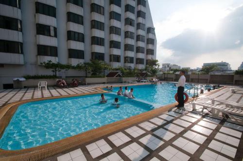 un grupo de personas en una piscina en un hotel en Omni Tower Sukhumvit Nana by Direct Rooms en Bangkok