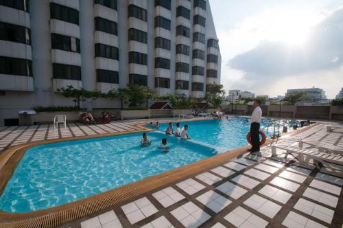 a group of people in a swimming pool at a hotel at Omni Tower Sukhumvit Nana by Direct Rooms in Bangkok