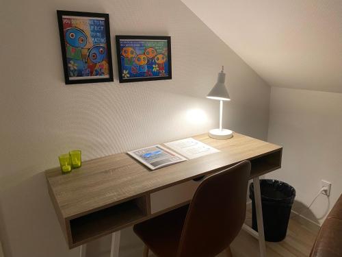 a desk with a lamp and two pictures on the wall at Nyopført luksusværelse i naturskønne og rolige omgivelser in Branderup