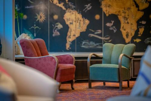 Pokój z dwoma krzesłami i mapą świata w obiekcie Hessenland Hotel Kassel Innenstadt by Stay Awesome w mieście Kassel