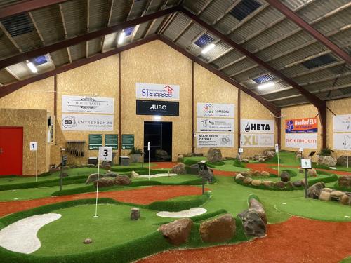a golf course exhibit in a large building with rocks at Hytten in Lemvig