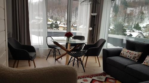 a living room with a table and chairs at Apartamenty Nowa Osada - by VillaOlimpijska2 in Wisła