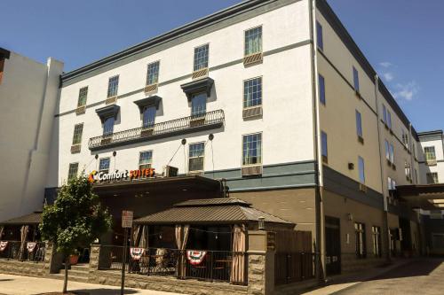 a large white building with a restaurant in front of it at Comfort Suites Downtown Carlisle in Carlisle