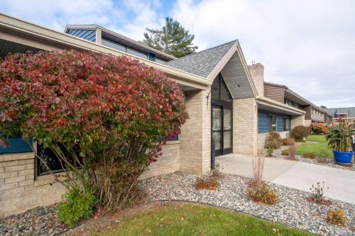 a house with a flowering bush in front of it at AmericInn by Wyndham Grand Rapids in Grand Rapids