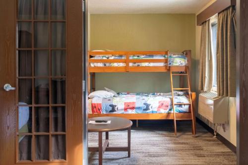a room with two bunk beds and a table at AmericInn by Wyndham Grand Rapids in Grand Rapids