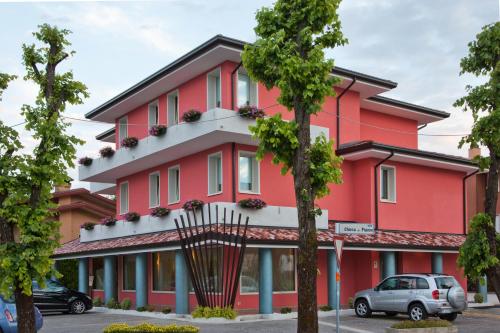 a red building with a tree in front of it at Ristorante Locanda Dussin in Oderzo