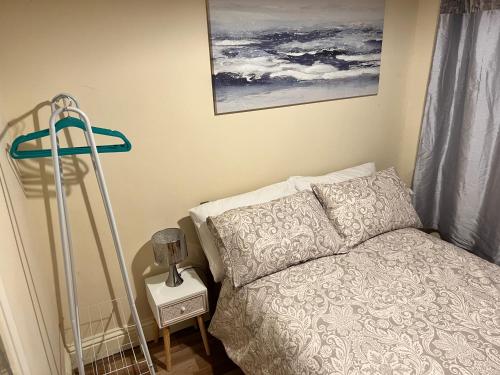 a small bedroom with a bed and a night stand at Reading West Homestay in Reading