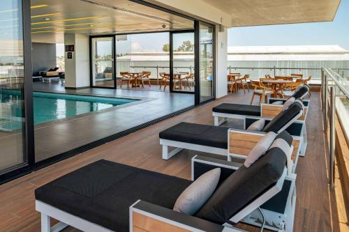an open living room with a pool and tables and chairs at Ramada Encore by Wyndham Guadalajara Aeropuerto in Guadalajara