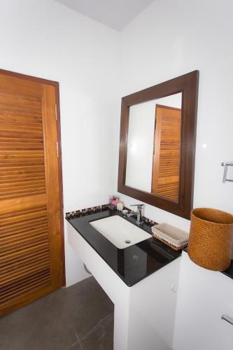 a bathroom with a sink and a mirror at Thararin Villa in Ban Doem Bang (1)