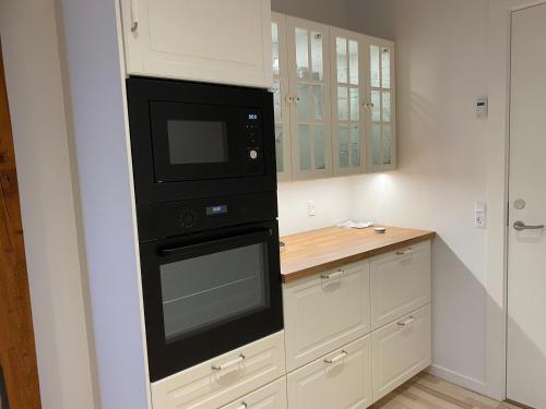 a kitchen with a black microwave and a counter at Nyopført luksusværelse i naturskønne og rolige omgivelser in Branderup