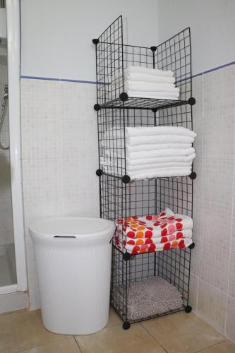 a towel rack with towels and a bucket in a bathroom at Apartamento Moradias Djadsal próximo à Praia de Santa Maria in Espargos