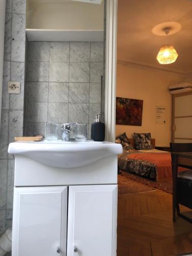 La salle de bains est pourvue d'un lavabo et d'un lit dans la chambre. dans l'établissement Cosy 2 room 50m2 Parisian classic flat - Passy, 16th arrondissement, near Eiffel Tower, à Paris