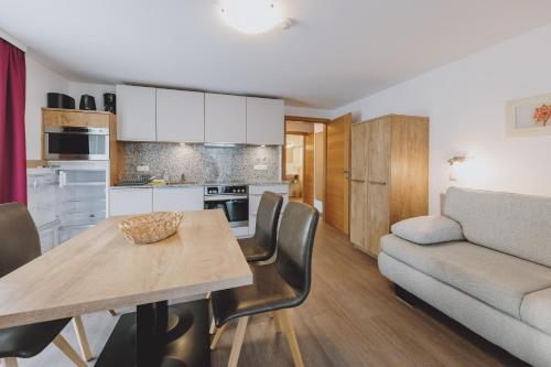 a kitchen and living room with a table and a couch at Appartements Sulzer by we rent, SUMMERCARD INCLUDED in Zell am See