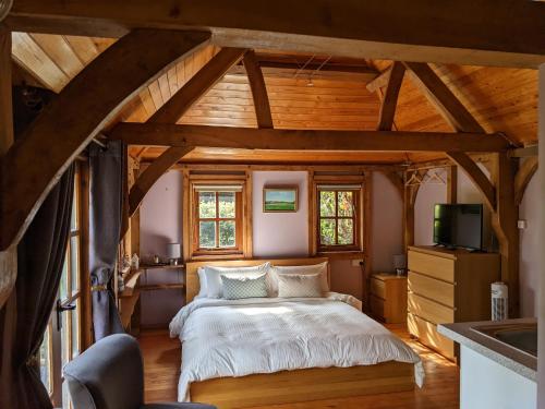 a bedroom with a bed in a room with wooden ceilings at Cabin in the Forest in Brockenhurst