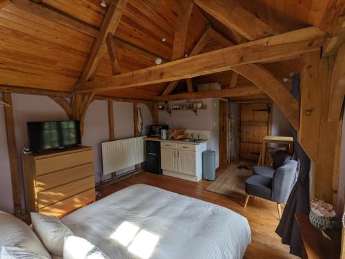 an attic room with a bed and a kitchen at Cabin in the Forest in Brockenhurst
