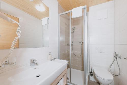 a bathroom with a shower and a sink and a toilet at Appartements Sulzer by we rent, SUMMERCARD INCLUDED in Zell am See