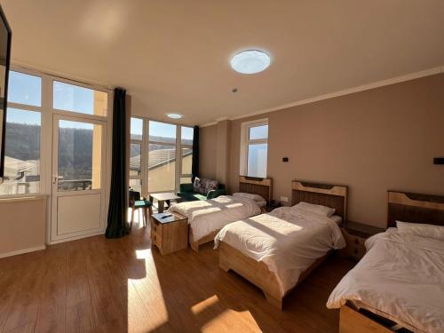 a bedroom with two beds and a large window at Ahval Hotel in Qusar