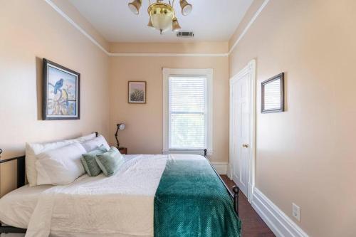 a bedroom with a bed and a chandelier at A+ 2 BR Victorian Home away from Home in Sacramento