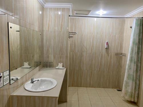 a bathroom with a sink and a shower at Albero Hotel Bogor in Bogor