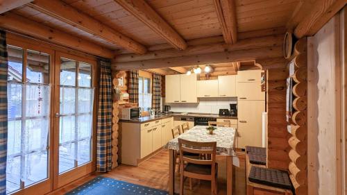 eine Küche mit einem Tisch und Stühlen in einer Hütte in der Unterkunft Blockhaus A in der Ziegelwies in Füssen
