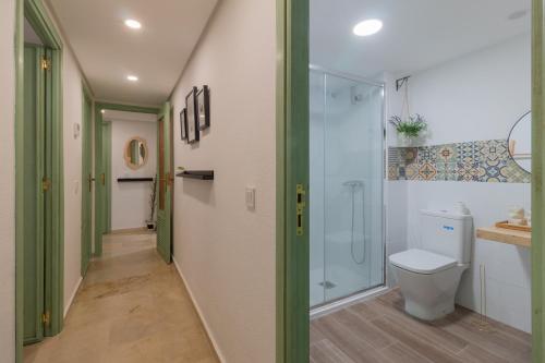 een badkamer met een toilet en een glazen douche bij Apartamento Céntrico Isaura in Córdoba