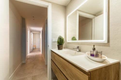 a bathroom with a sink and a mirror at SIAT VIVIENDAS Villa carretera LA BARROSA in Chiclana de la Frontera