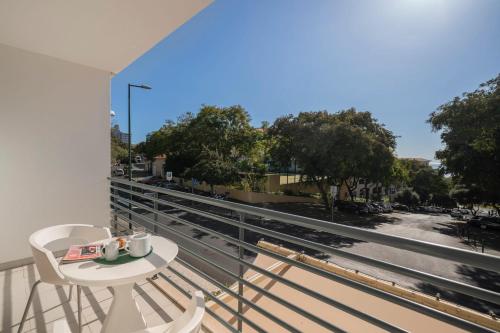 a balcony with a table and chairs and a view of a street at Lido View Place by An Island Apart in Funchal