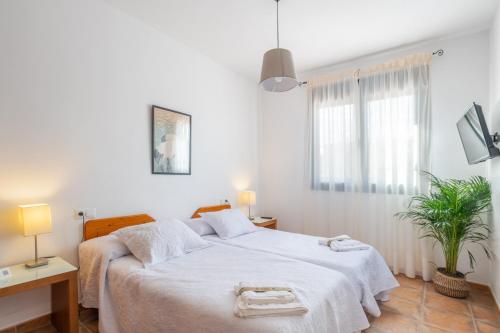 a bedroom with a white bed with two towels on it at Hotel Rural El Castillejo in Cuevas del Becerro