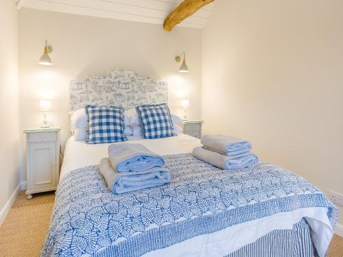 a bedroom with a bed with blue towels on it at The Stables - Uk41887 in Peasmarsh