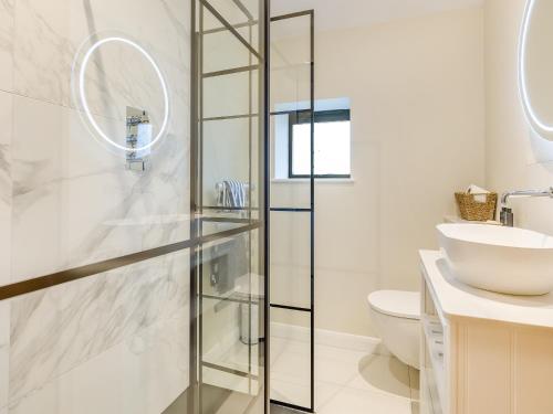 a bathroom with a glass shower stall and a sink at The Stables - Uk41887 in Peasmarsh