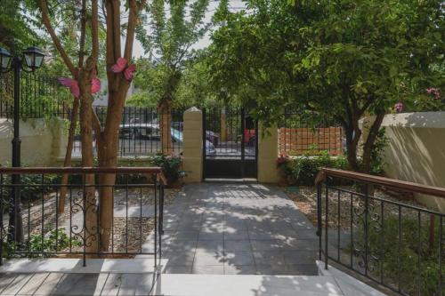 a walkway with a wrought iron gate and trees at Maisonette Lucia Traditional House Prime Location in Piraeus