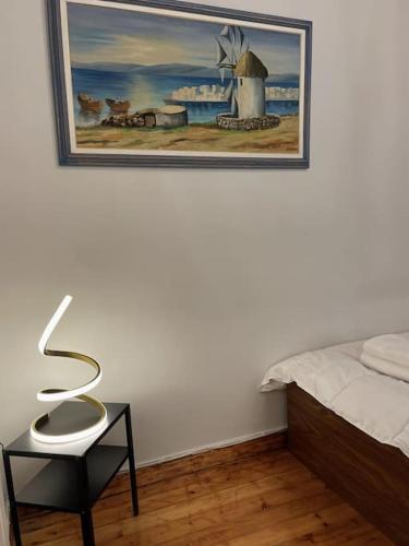a bedroom with a bed and a picture on the wall at Maisonette Lucia Traditional House Prime Location in Piraeus