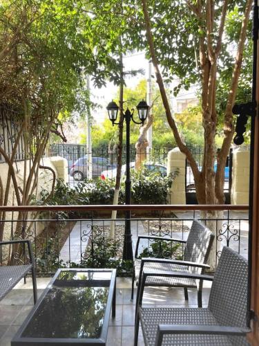 a group of chairs and tables on a patio at Maisonette Lucia Traditional House Prime Location in Piraeus