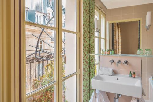 a bathroom with a sink and a window at Hotel Le petit Paris in Paris