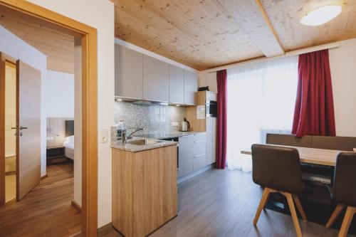 a kitchen and dining room with a table and a counter at Appartements Sulzer by we rent, SUMMERCARD INCLUDED in Zell am See