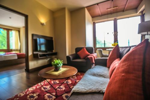 ein Wohnzimmer mit einem Sofa und einem Tisch in der Unterkunft The Pema by Realm in Thimphu