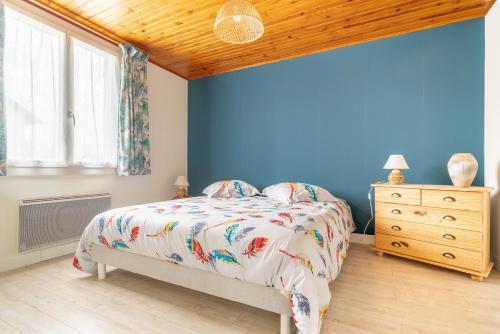 une chambre avec un lit et un mur bleu dans l'établissement L'Argentique, à Ceffonds