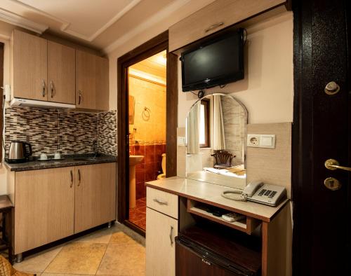 a kitchen with a tv on the wall at Sultanahmet Black Pearl Apart Hotel in Istanbul