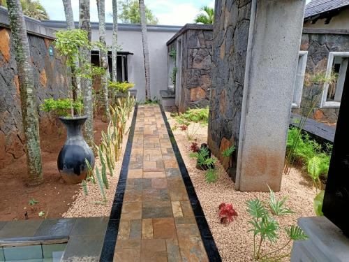 a garden with a large vase sitting on a walkway at Villa The Flows at Belle Rivière in Bel Ombre