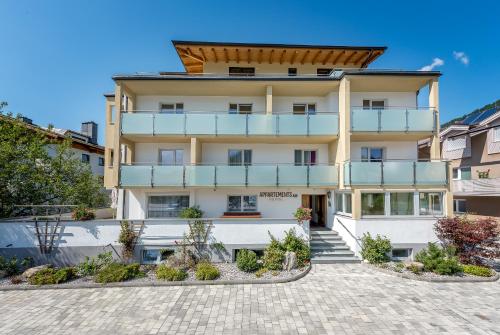 een groot wit gebouw met een balkon bij Appartements Sulzer by we rent, SUMMERCARD INCLUDED in Zell am See